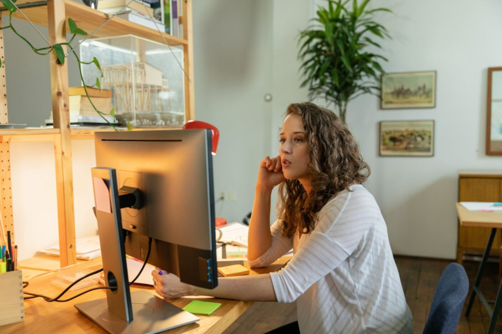 Woman researching how to start a cleaning business from her home office desk